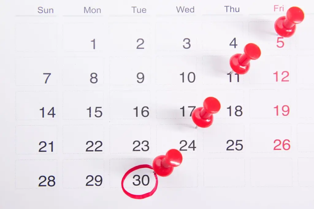 Calendario con un día marcado con un círculo rojo y chinchetas