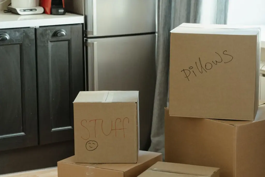 Cocina con frigorífico y cajas de cartón preparadas para la mudanza