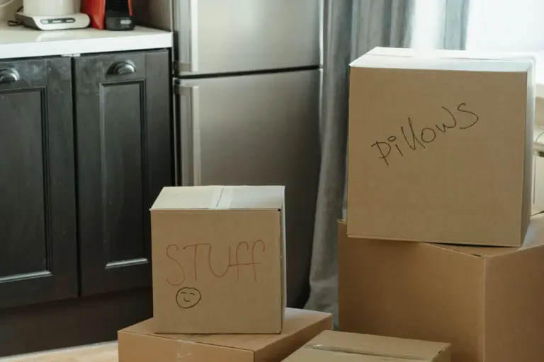 Cocina con frigorífico y cajas de cartón preparadas para la mudanza