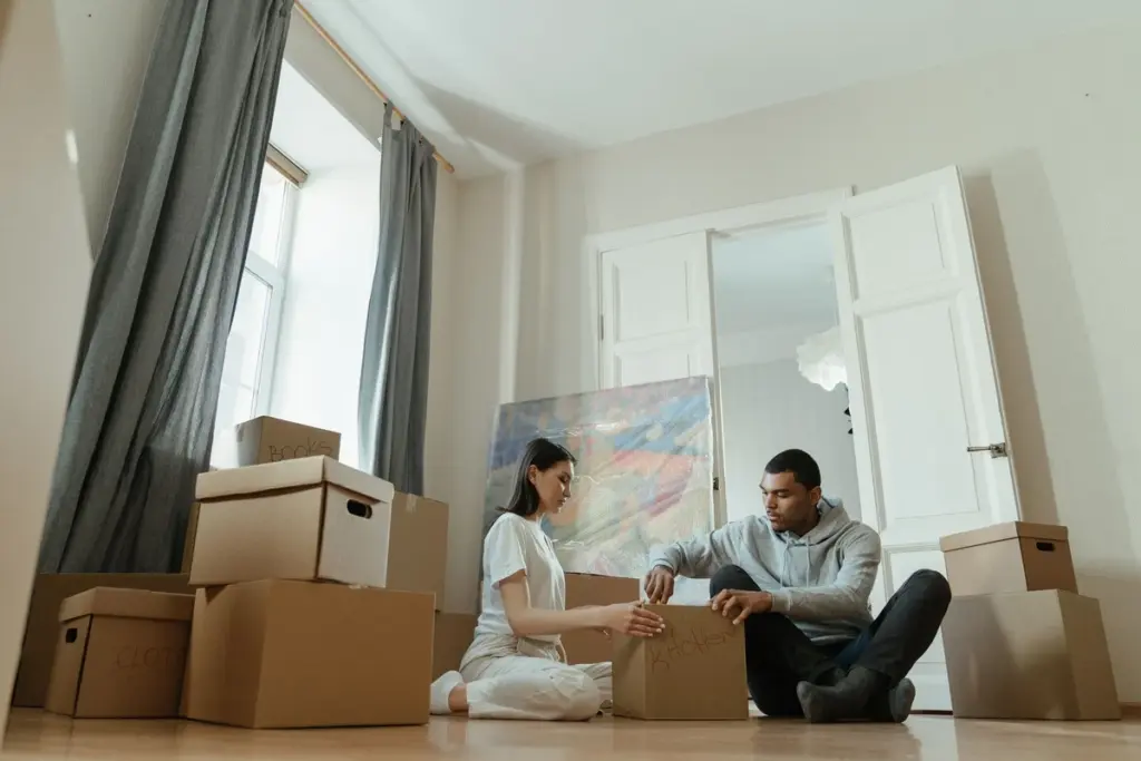 Pareja abriendo cajas de la mudanza en su casa nueva