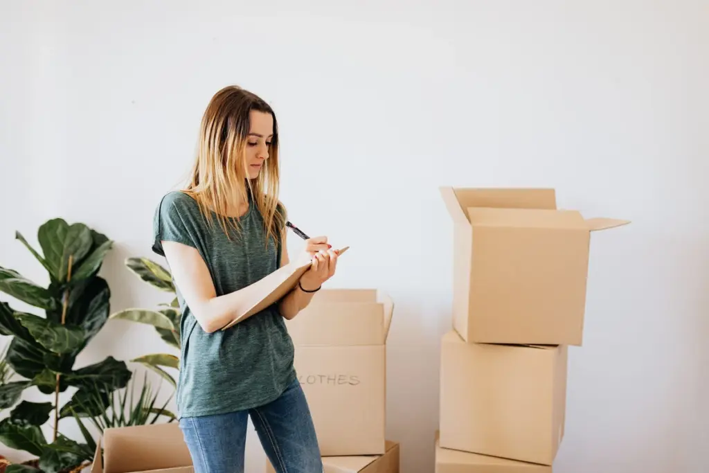 Persona anotando el inventario de cajas de la mudanza en una libreta