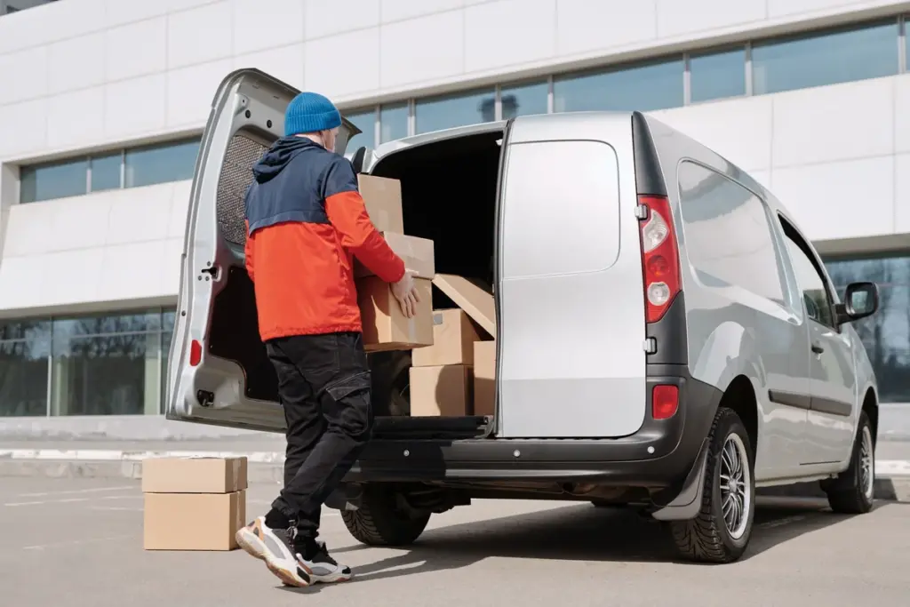 Persona cargando cajas de cartón en una furgoneta